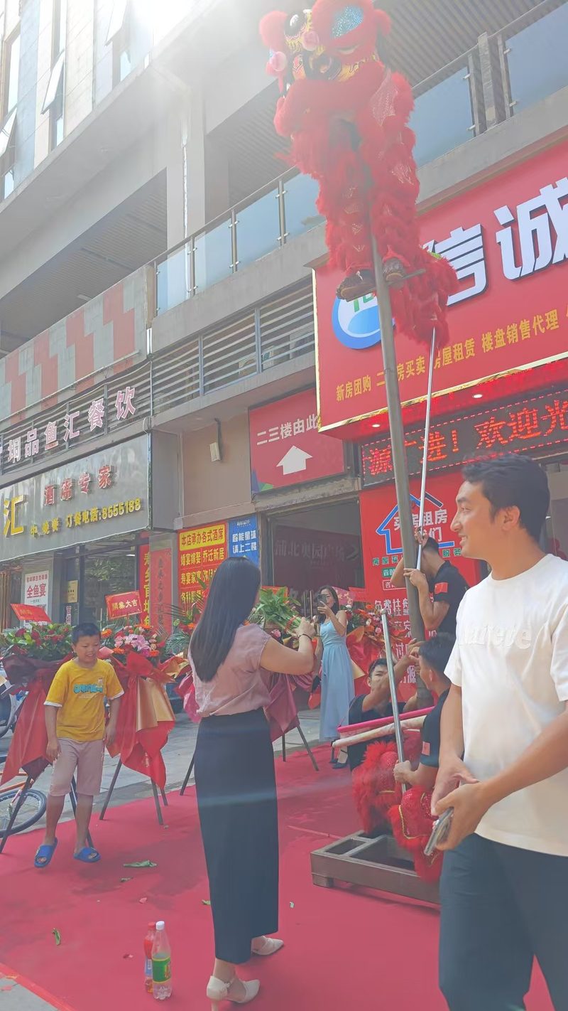 浦北信诚房产奥园广场直营店开业当天的醒狮祈福表演，狮子登上高杆